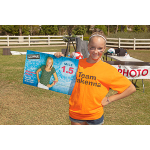 Makenna proudly posing with her Mile Marker.